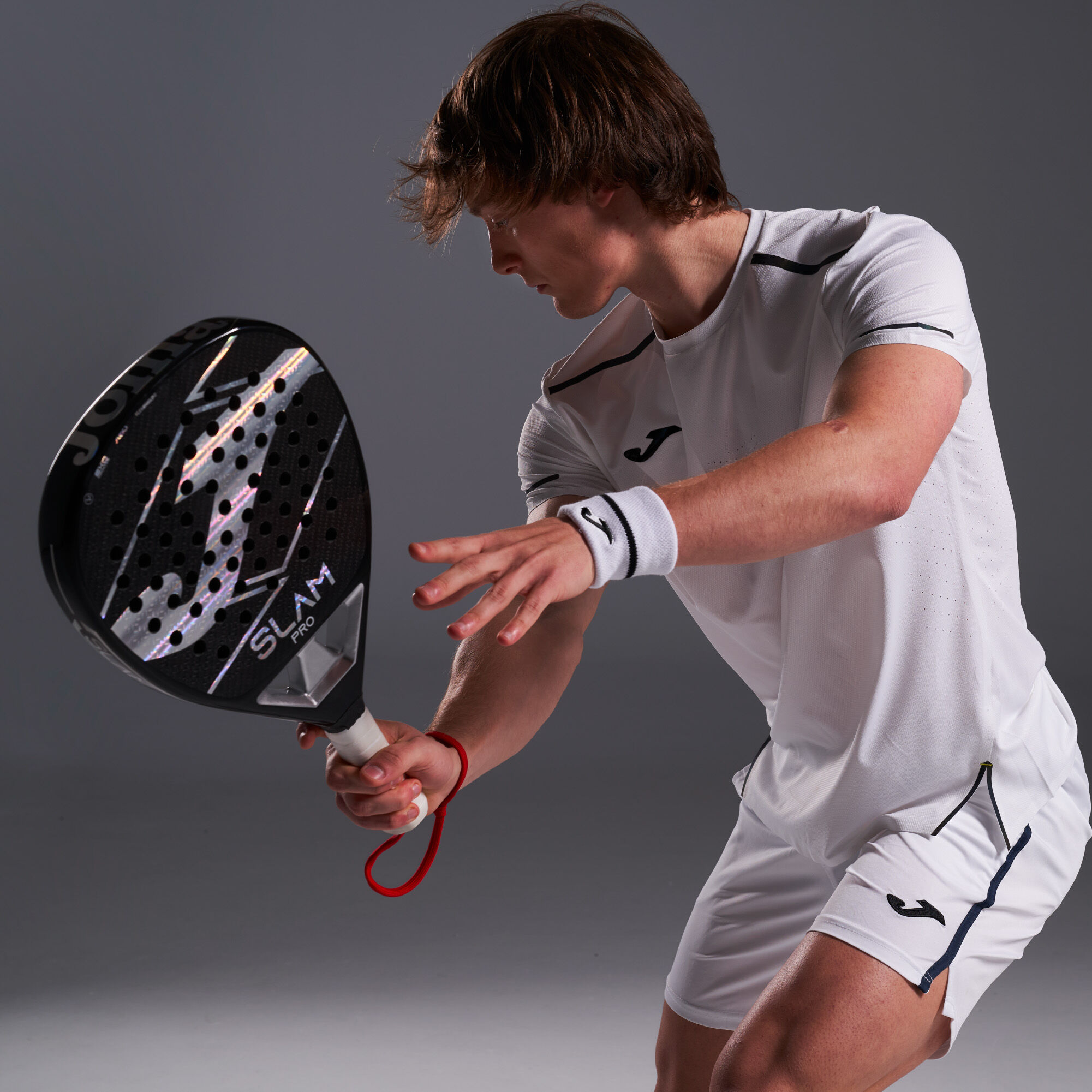 Chico sujetando Pala de pádel SLAM PRO negro plata