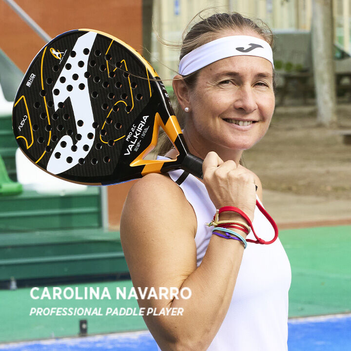 Carolina Navarro sujetando su Pala de pádel Valkiria Pro Carolina Navarro negro naranja